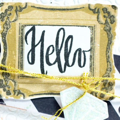 Close-up of card with Hello in a gold frame by Taheerah Atchia