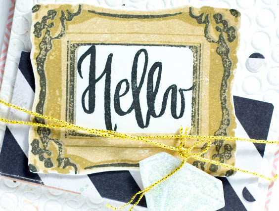 Close-up of card with Hello in a gold frame by Taheerah Atchia